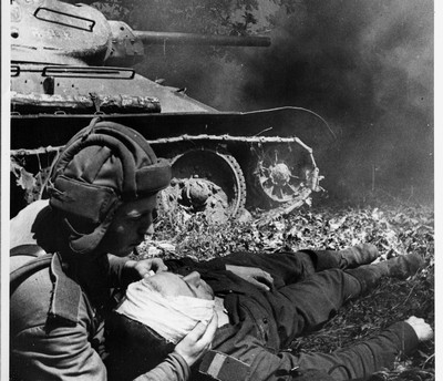 Танкист подбитой «тридцатьчетвёрки» перевязывает своего товарища Трагичная победа